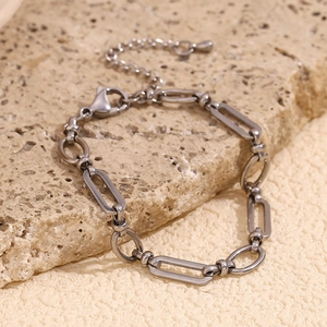 Detail of silver stainless steel paperclip chain bracelet with lobster clasp on stone