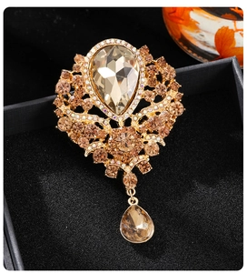Detailed macro view of vintage crystal brooch with champagne drop pendant in gift box