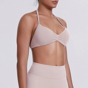 Detail view of pink halter sports bra with ribbed texture and high waist leggings