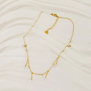 Elegant gold chain necklace with round crystal zircon tassels on white artistic background
