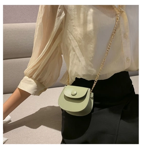 Gros plan du mini sac selle vert clair en cuir PU avec bandoulière chaîne dorée sur mannequin
