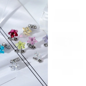 Detailed view of star-shaped dermal tops with multi-color zircon stones in claw settings