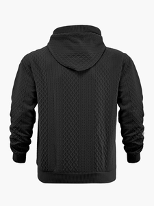 Detailansicht der schwarzen Jacquard-Strickstruktur und des Stoffmusters am Hoodie