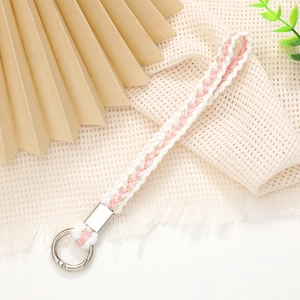 Detail of hand-woven phone strap with white, pink, and gold threads and metal clasp
