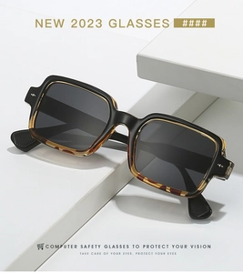 Detail of retro square frame sunglasses with rice nail accents on a white display stand