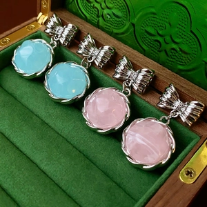 Orecchini vintage in resina con fiocco in blu cielo e rosa su velluto verde scuro