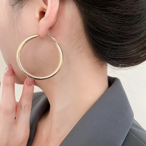 Poliertes Gold-Creolen-Set an Model im minimalistischen und geometrischen Design