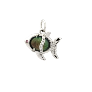 Macro shot of silver fish pendant with dark green gemstone and shimmering zircon accents