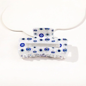 Detailed close-up of white acetate hair claw clip featuring evil eye print pattern