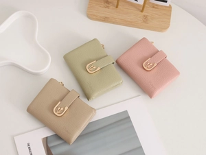 Three leather wallets in green, pink and beige with tulip metal buckles and pebble texture