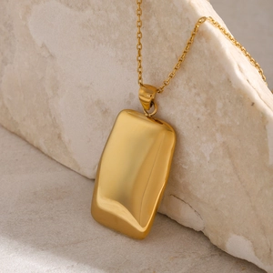 Polished 18k gold plated rectangular pendant necklace on a minimalist stone