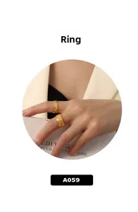 Close-up of quilted pattern gold rings in wide and narrow styles on a hand