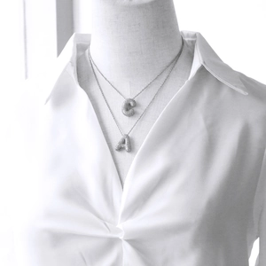 Layered silver metal necklace with iced out C and A letter pendants set with shiny zircons