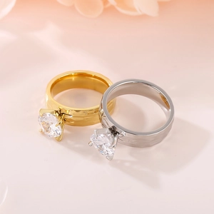 Detail of gold and silver hammered band rings with four-prong set cubic zirconia