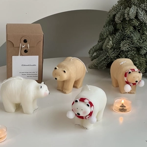 Close-up of polar bear candles with red scarves and festive Christmas decorations