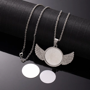 Detail showing silver wing pendant with rhinestones and sublimation blanks on black base