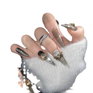 Gothic stiletto press-on nails with black cat eye effect and 3D bat skull charms