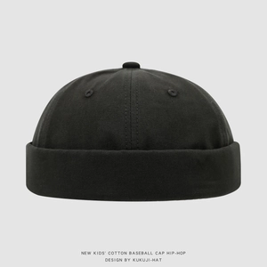 Détail d'un bonnet docker noir pour enfants avec bord roulé sans bordure et bouton supérieur