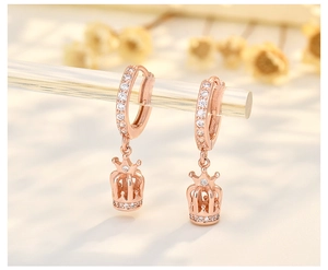 Macro shot of rose gold crown earrings with sparkling zircons and fine craftsmanship