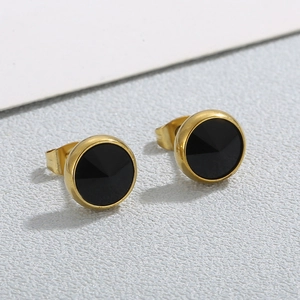 Vue macro de boucles d'oreilles rondes dorées avec insert de pierre noire élégante
