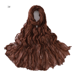 Detail view of brown breathable cotton scarf showing crinkle texture and lightweight fabric