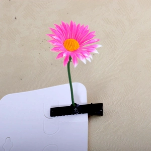 Close-up of pink daisy hair clip with black metal duckbill clip on display card
