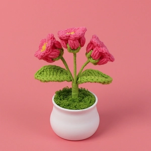 Detail showing pink crochet lily of the valley flowers in a white ceramic pot