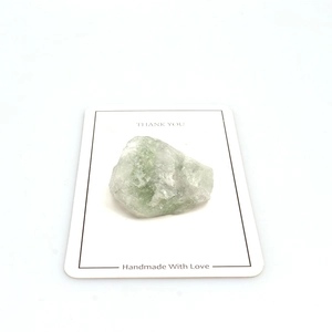 Natural green fluorite crystal specimen on decorative Thank You card on white background