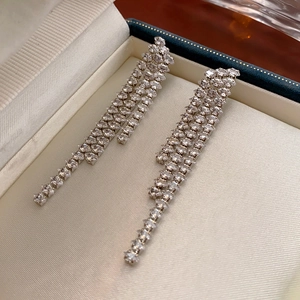 Close-up of sparkling silver tassel earrings with diamonds in a luxury jewelry box