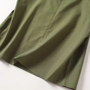 Detail of olive green cotton linen fabric texture and stitching on casual wide-leg pants