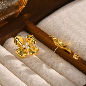Detailed macro view of golden flower earrings with white pearls in a jewelry box