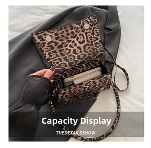 Dettaglio della borsa leopardata che mostra la capacità interna e i bottoni magnetici