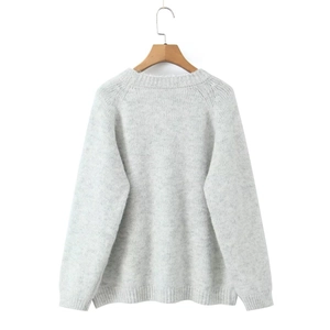 Detail of light gray knit sweater texture with soft mohair finish on a wooden hanger