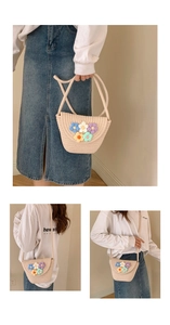 Detailed view of handmade beige straw bucket bag with colorful crochet floral patterns