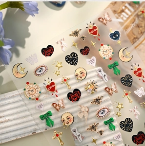 Macro view of retro nail art stickers featuring vintage clock, heart and moon motifs