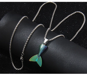 Macro shot of colorful mermaid tail pendant with box chain on black leather stand