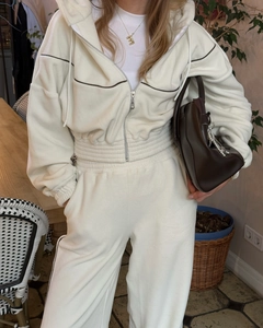 Détail d'un sweat à capuche blanc et d'un pantalon à taille haute avec liserés noirs