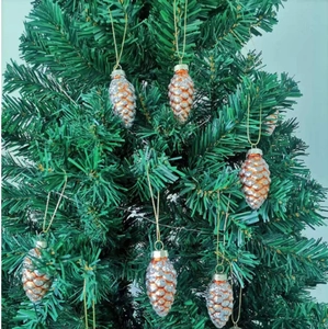 Close-up of amber pinecone Christmas ornaments with silver glitter hanging on a tree