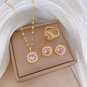 Elegant gold-plated jewelry set with square-shaped pink stones on white silk fabric