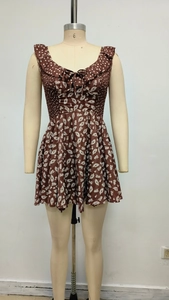 Detail of ruffle neckline with tie strings and shirred polka dot bodice on brown dress