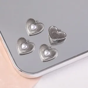 Gros plan du pendentif coeur argenté avec texture radiale et perle, taille 18x20mm