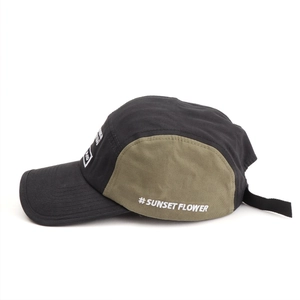 Detail of 5-panel baseball cap showing side embroidery and green color block stitching