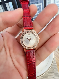 Detailed macro view of a women's quartz watch with red crocodile leather strap and crystals