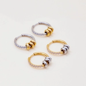 Detailed view of bicolor 18K gold-plated stainless steel hoop earrings with inset crystals