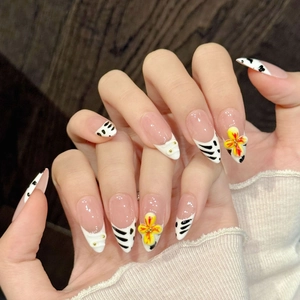 Pink French nails with black zebra patterns and 3D yellow flower accents on wood background