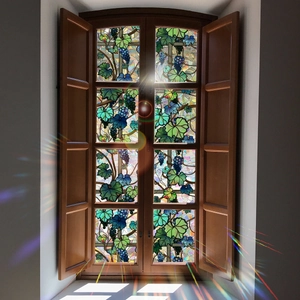 Colorful vine and grape window film projecting rainbow light on a wooden window frame