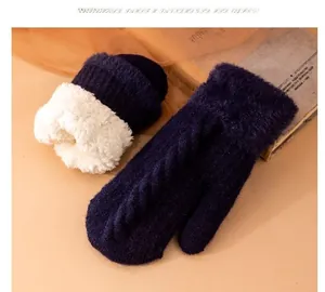 Dettaglio guanto in maglia blu scuro con fodera in pile bianco e trama a treccia