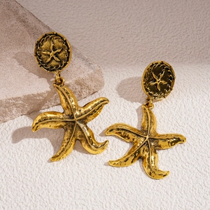 Detailed close-up of vintage golden starfish earrings with geometric textured finish