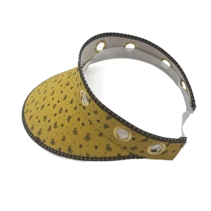 Close-up of ginger yellow floral sun visor with retro polka dot trim and metal eyelets