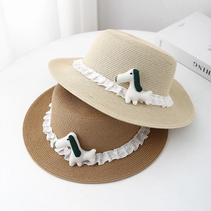 Close-up of woven straw hat featuring delicate white lace trim and cute puppy ornament
